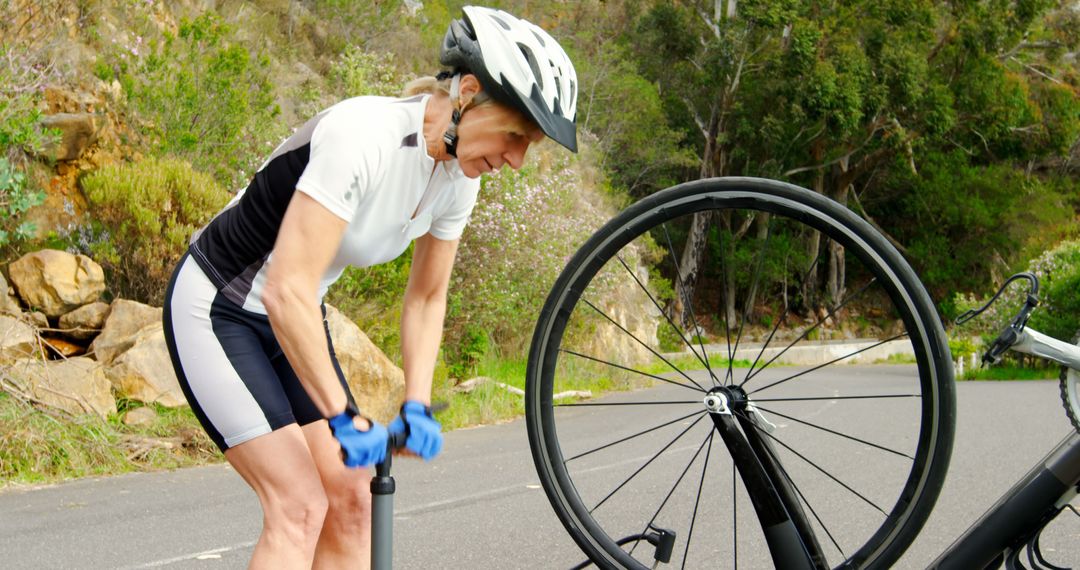 Cyclist Pumping Tire on Roadside in Nature - Free Images, Stock Photos and Pictures on Pikwizard.com