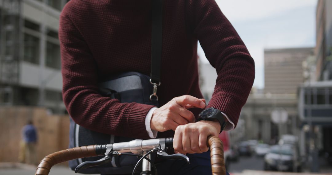 Man Checking Smartwatch While Riding Bicycle in Urban Area - Free Images, Stock Photos and Pictures on Pikwizard.com