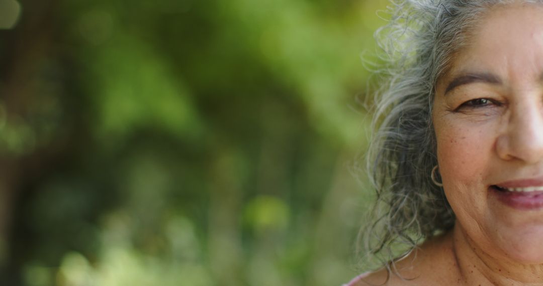 Senior Woman Smiling Outdoors with Gray Hair in Natural Setting