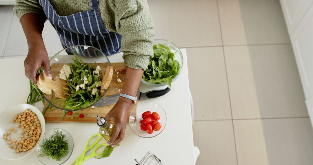 Senior Woman Preparing Fresh Salad in Bright Kitchen - Free Images, Stock Photos and Pictures on Pikwizard.com