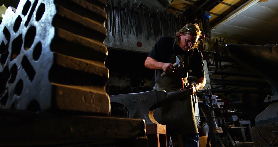Determined Blacksmith Crafting Metal in Workshop