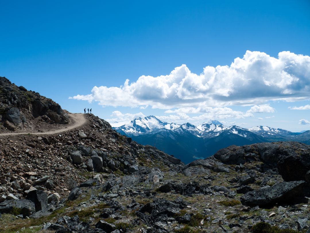 Hikers exploring rugged mountain trail with snow-capped peaks - Free Images, Stock Photos and Pictures on Pikwizard.com