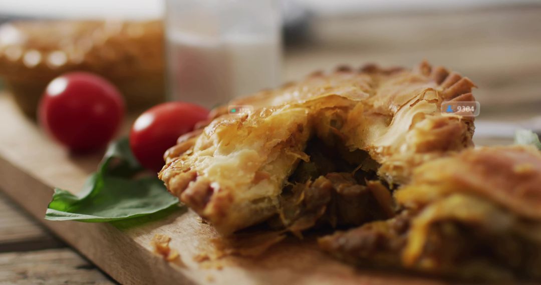 Rustic torn meat and cheese hand pie with golden crust on wooden board with tomatoes basil