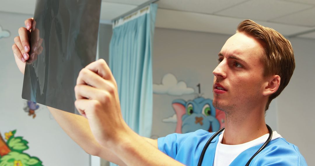 Young Male Medical Professional Examining X-Ray in Hospital Room - Free Images, Stock Photos and Pictures on Pikwizard.com