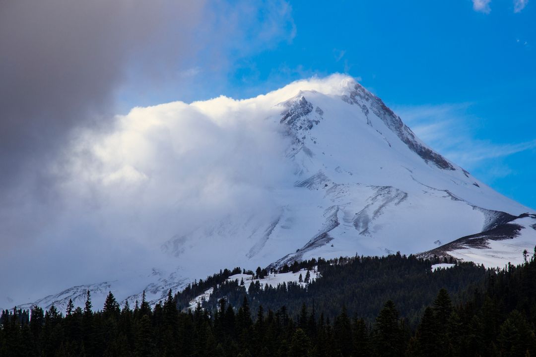 Snow-covered Mountain Peak with Misty Clouds and Blue Sky  - Free Images, Stock Photos and Pictures on Pikwizard.com