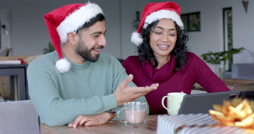 Smiling Couple Wearing Santa Hats Video Calling During Christmas Celebration - Free Images, Stock Photos and Pictures on Pikwizard.com