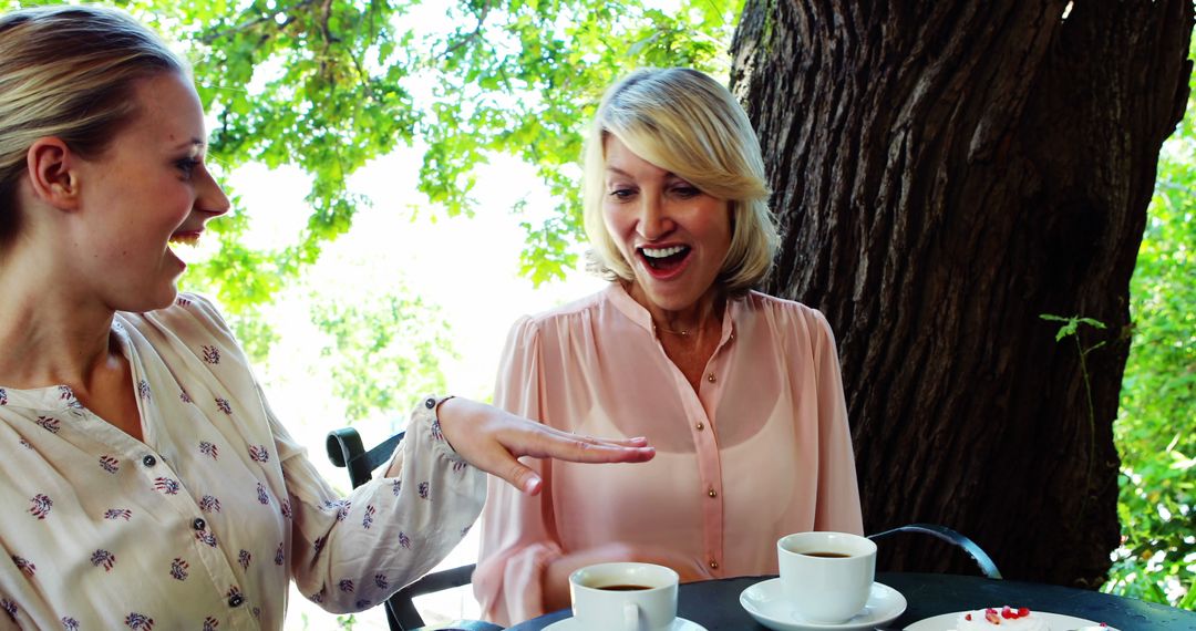 Women Enjoying Conversation Over Coffee in Outdoor Cafe with Smiling Faces - Free Images, Stock Photos and Pictures on Pikwizard.com