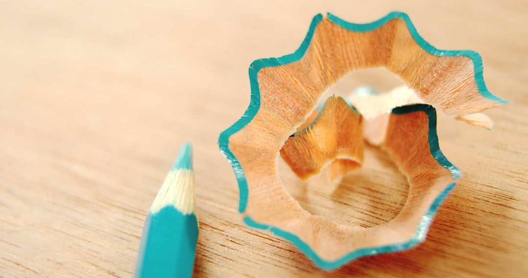 Close-up of turquoise pencil shavings and sharpened pencil on wooden surface - Free Images, Stock Photos and Pictures on Pikwizard.com