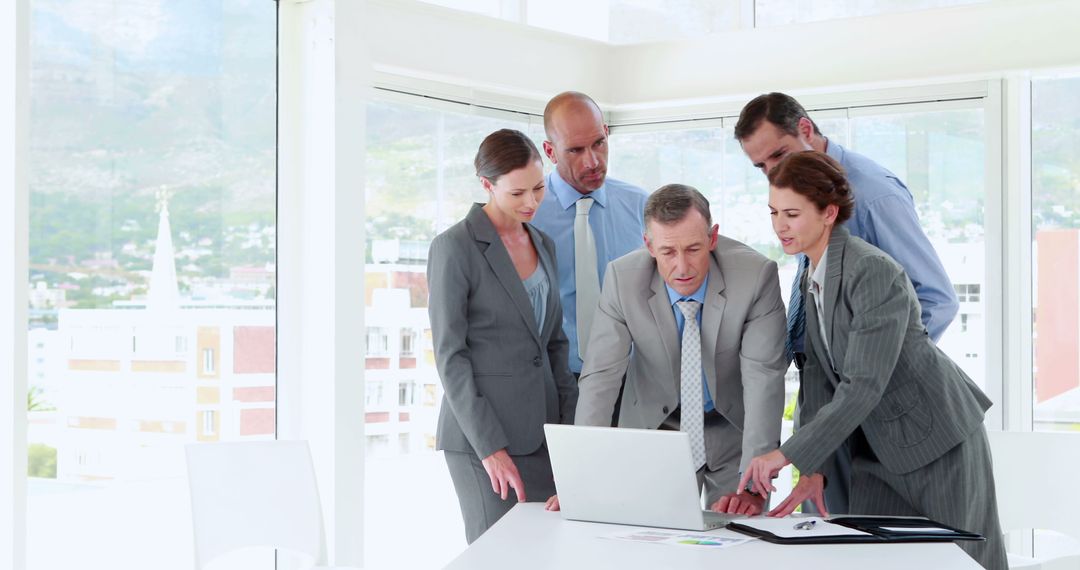 Business Team Analyzing Data on Laptop During Meeting