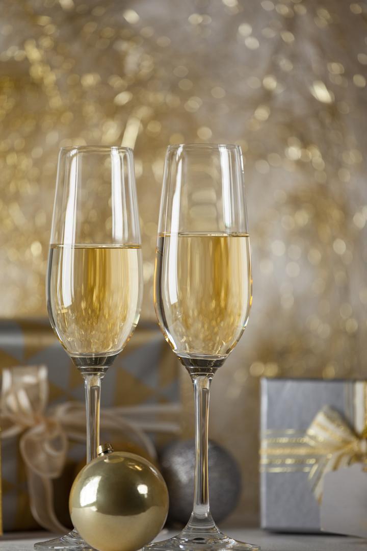 Two champagne flutes and Christmas gifts - Free Images, Stock Photos and Pictures on Pikwizard.com