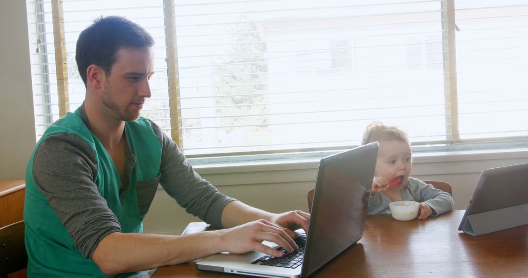 Father Working on Laptop with Child Using Tablet - Free Images, Stock Photos and Pictures on Pikwizard.com