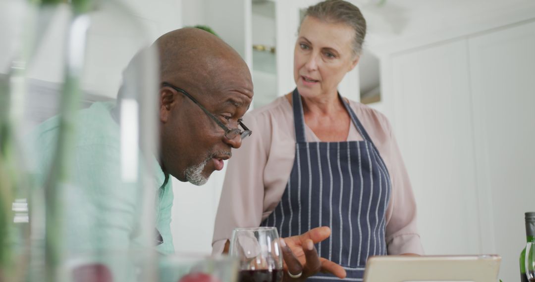 Senior Couple Cooking Together Using Tablet