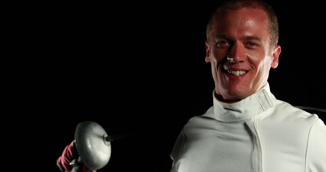 Confident Fencer Holding Epee Sword in Dark Background - Free Images, Stock Photos and Pictures on Pikwizard.com