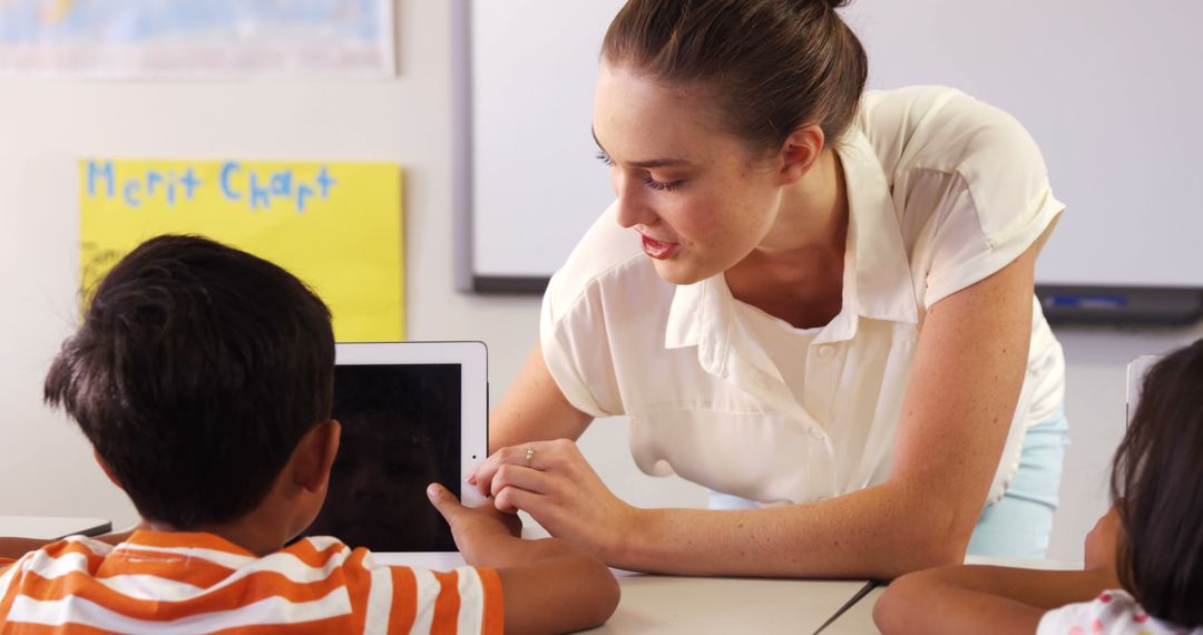 Teacher Guiding Students Using Digital Tablet in Classroom - Free Images, Stock Photos and Pictures on Pikwizard.com