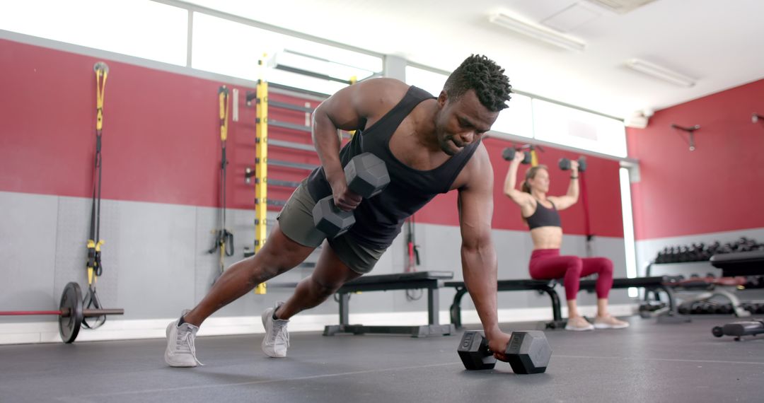 Athletic Man Performing Dumbbell Push-Ups in Gym Session
