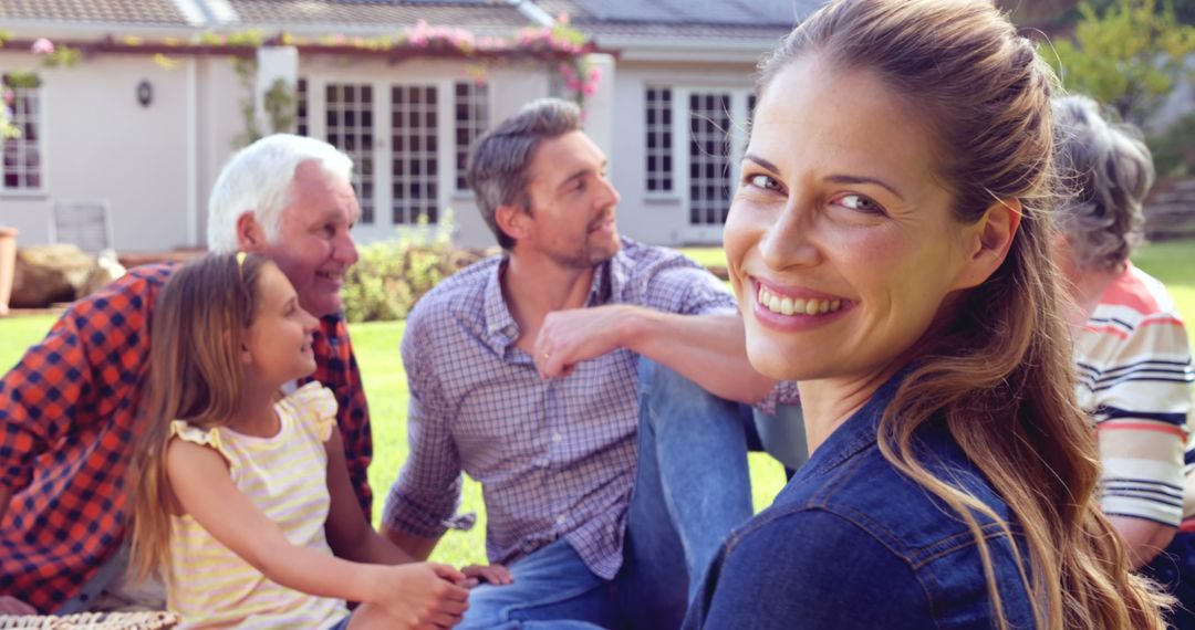 Smiling Woman with Family Relaxing in Garden on Sunny Day - Free Images, Stock Photos and Pictures on Pikwizard.com