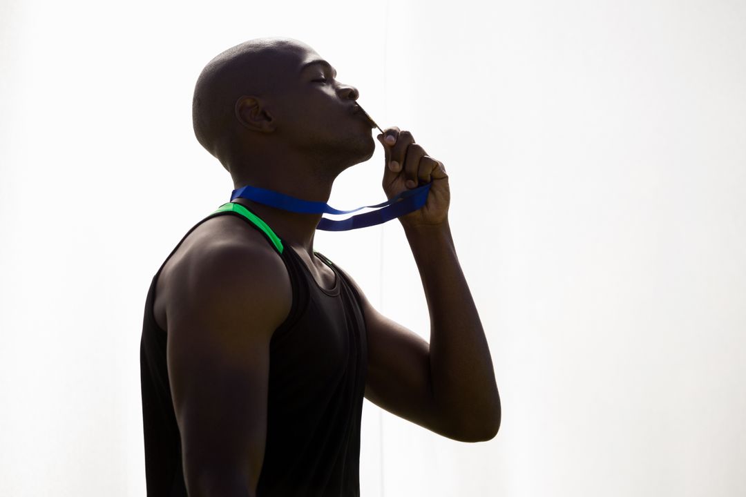 Athlete kissing his gold medal - Free Images, Stock Photos and Pictures on Pikwizard.com