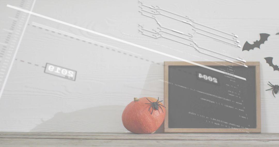 Displaying small pumpkin with plastic spider on rustic wood table with chalkboard and bats