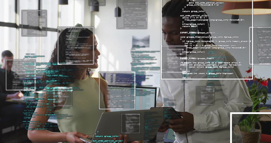 Colleagues Reviewing Code on Laptop and Tablet in Modern Office