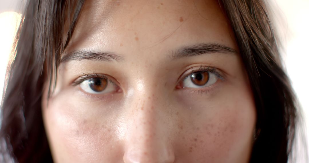 Close-up of Woman's Eyes with Freckles, Expressing Deep Contemplation
