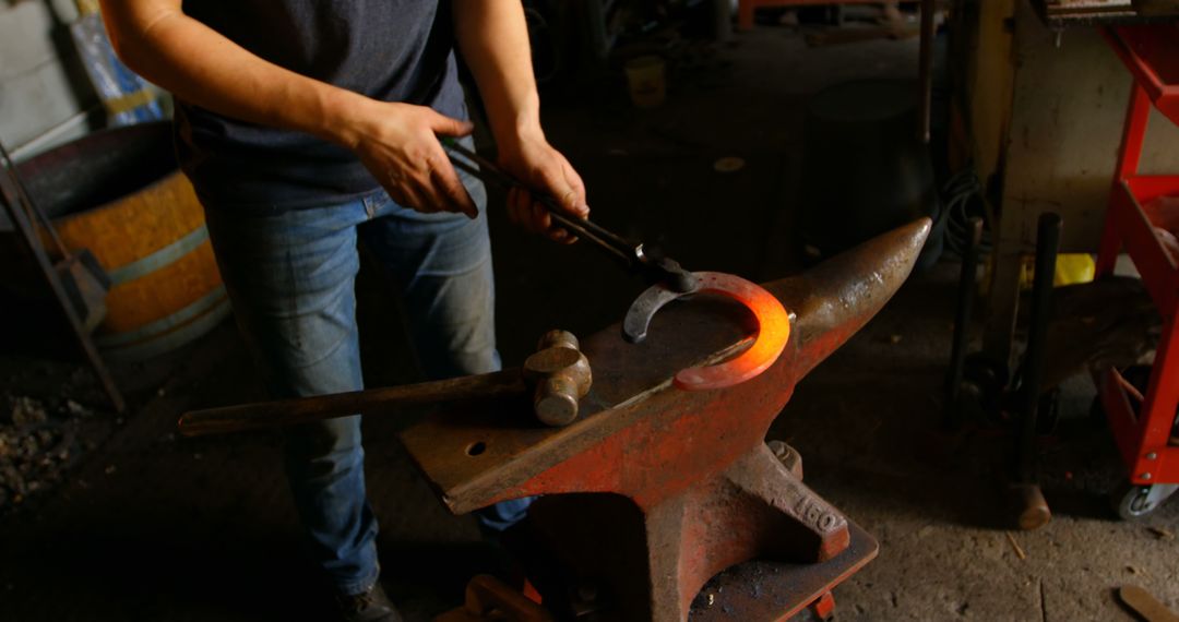 Blacksmith crafting heated iron horseshoe on anvil with hammer - Free Images, Stock Photos and Pictures on Pikwizard.com