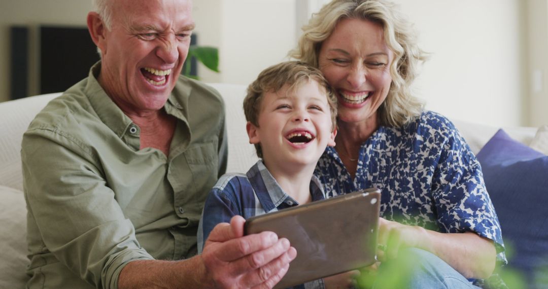Happy Grandparents with Grandson Enjoying Digital Entertainment