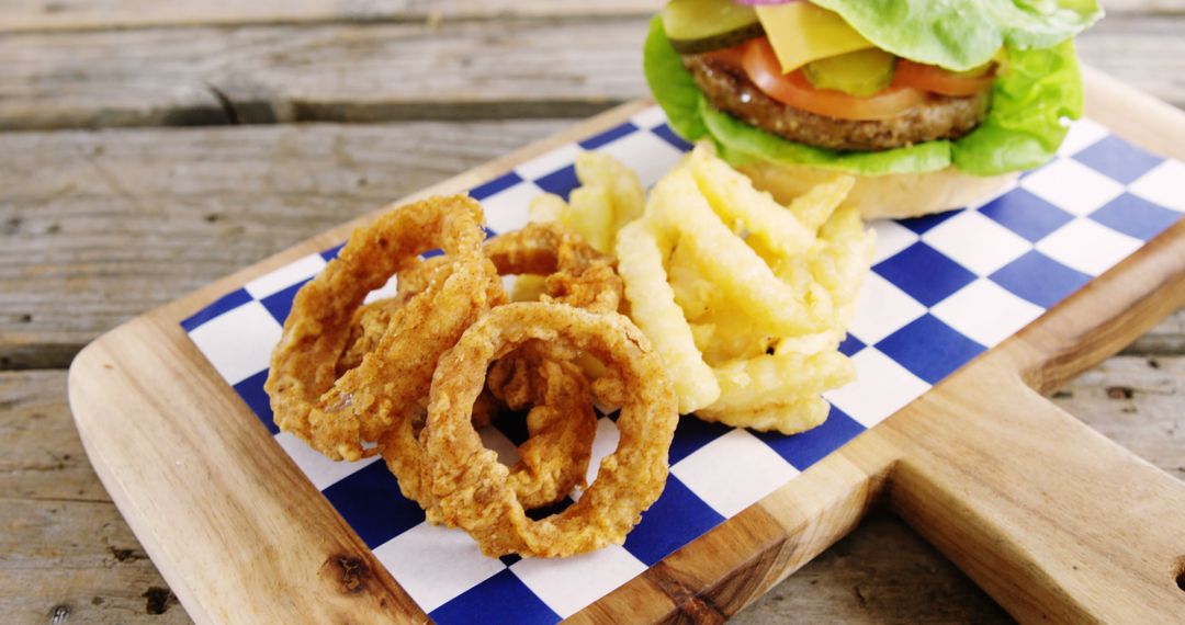 Delicious Burger with Onion Rings and French Fries on Rustic Wooden Platter - Free Images, Stock Photos and Pictures on Pikwizard.com