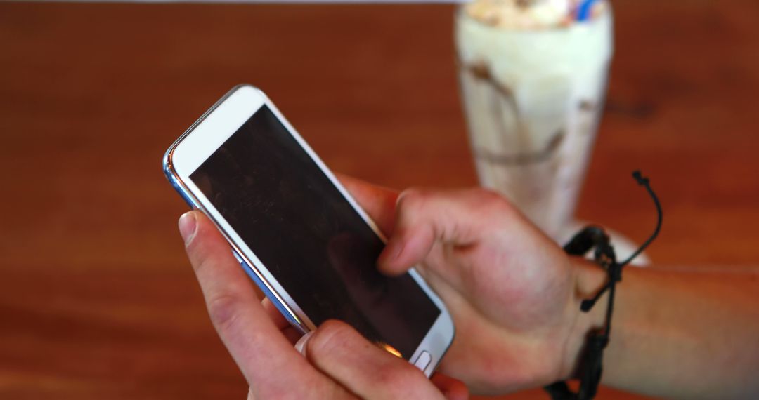 Close-up of Person Using Smartphone with Milkshake in Background - Free Images, Stock Photos and Pictures on Pikwizard.com