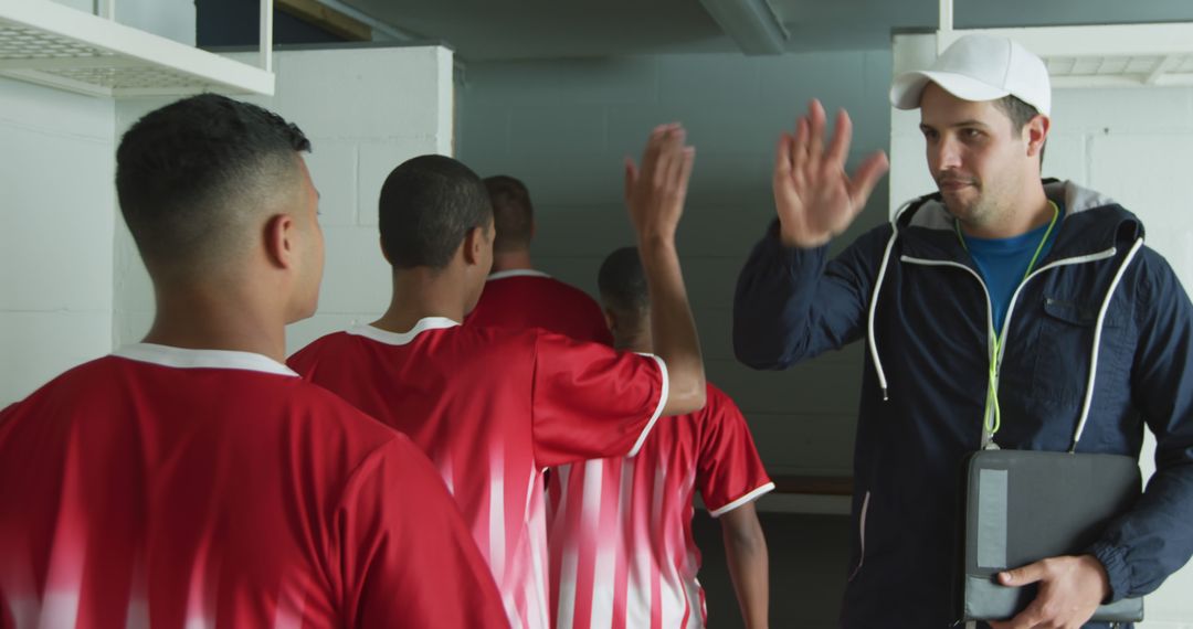 Soccer Coach High-Fiving Players in Locker Room - Free Images, Stock Photos and Pictures on Pikwizard.com