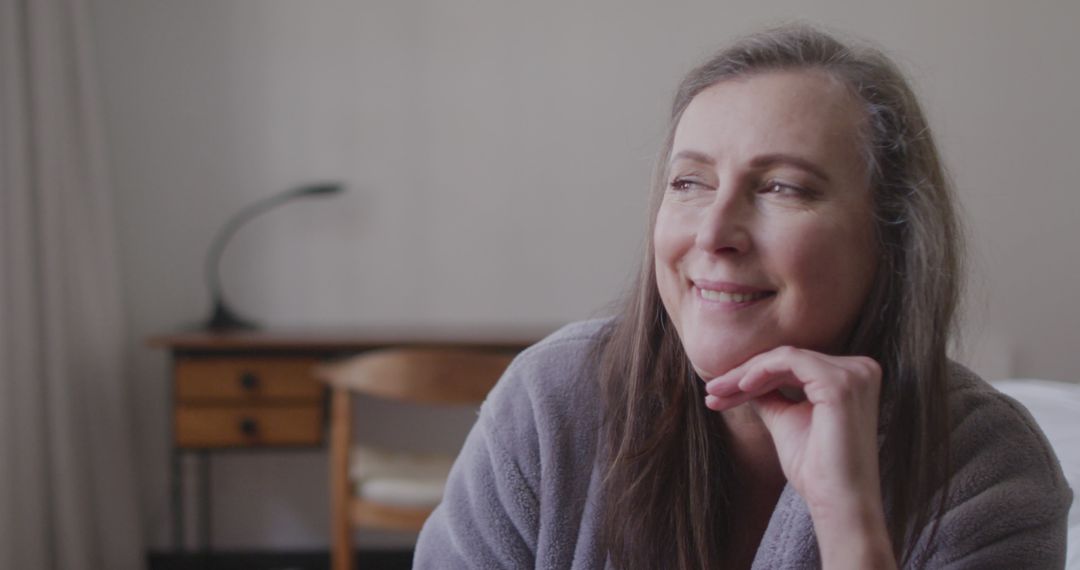 Middle-Aged Woman Smiling Thoughtfully in Cozy Room - Free Images, Stock Photos and Pictures on Pikwizard.com