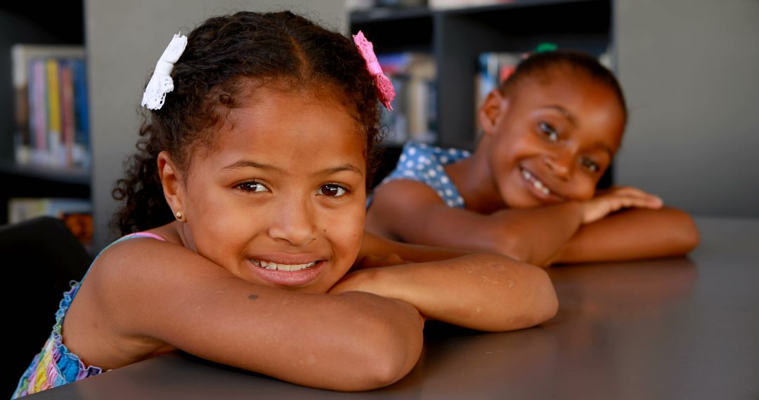 Two Smiling African American Girls Relaxing in Library - Free Images, Stock Photos and Pictures on Pikwizard.com