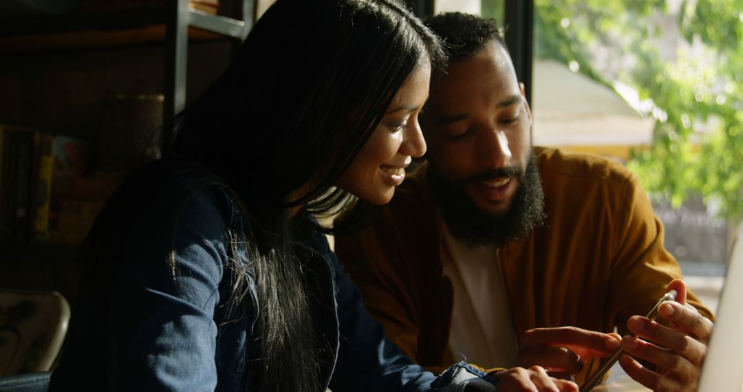 Couple Sharing Smartphone Experience in Cozy Cafe