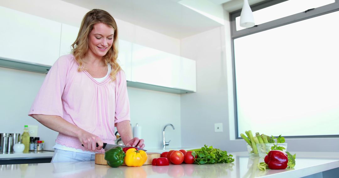 Smiling Woman Cutting Vegetables in Modern Kitchen - Free Images, Stock Photos and Pictures on Pikwizard.com