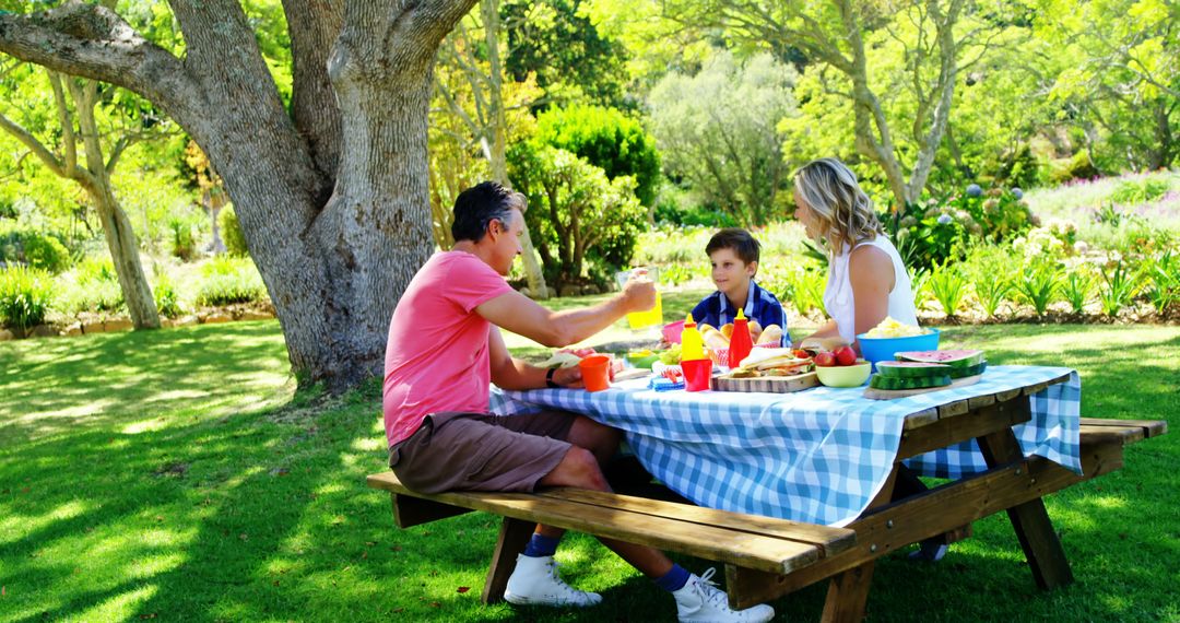 Family Enjoying Picnic Under Tree in Summer Park - Free Images, Stock Photos and Pictures on Pikwizard.com