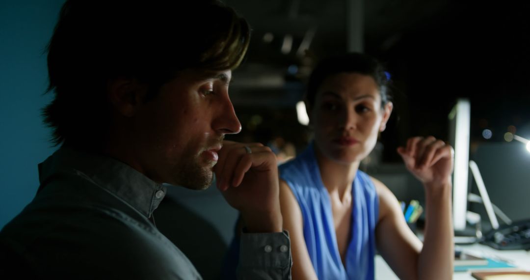 Office Colleagues Discussing Over Computer Late Evening