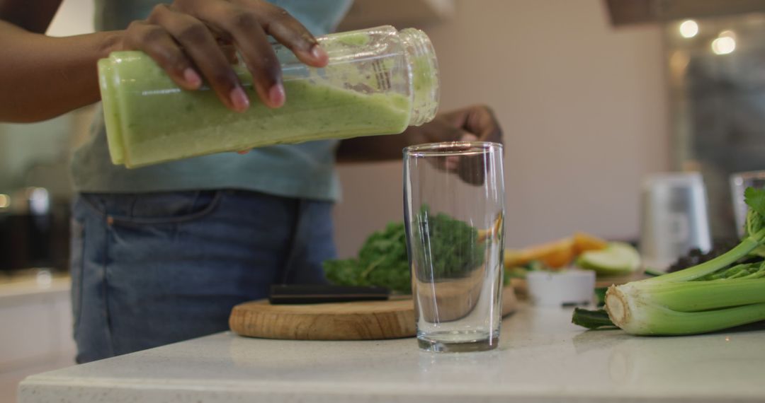 Person Pouring Green Smoothie Into Glass In Kitchen - Free Images, Stock Photos and Pictures on Pikwizard.com