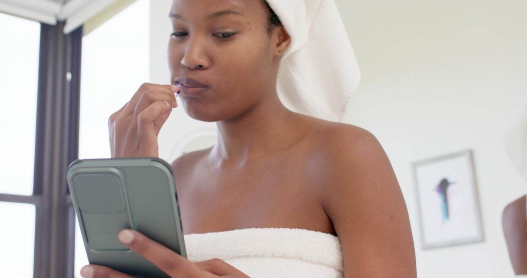 Woman in Towel Texting on Smartphone in Bright Bathroom - Free Images, Stock Photos and Pictures on Pikwizard.com