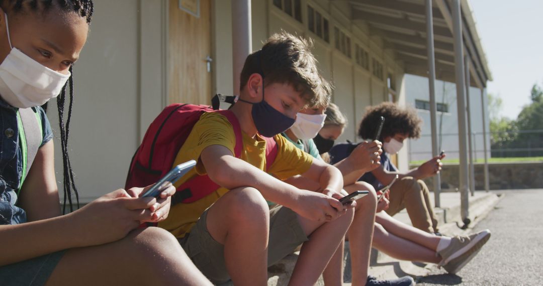 Diverse Students Outdoors Using Smartphones Wearing Face Masks - Free Images, Stock Photos and Pictures on Pikwizard.com