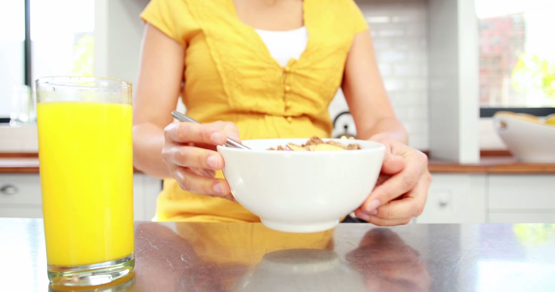 Woman Having Breakfast with Fruit Juice in Modern Kitchen - Free Images, Stock Photos and Pictures on Pikwizard.com