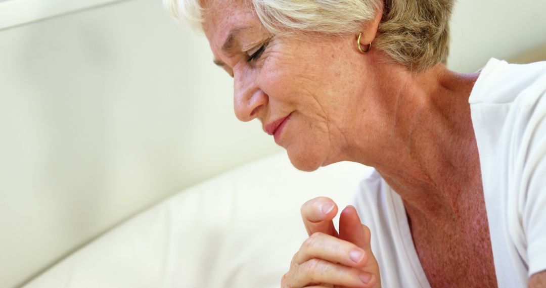 Senior Woman Praying with a Serene Expression - Free Images, Stock Photos and Pictures on Pikwizard.com