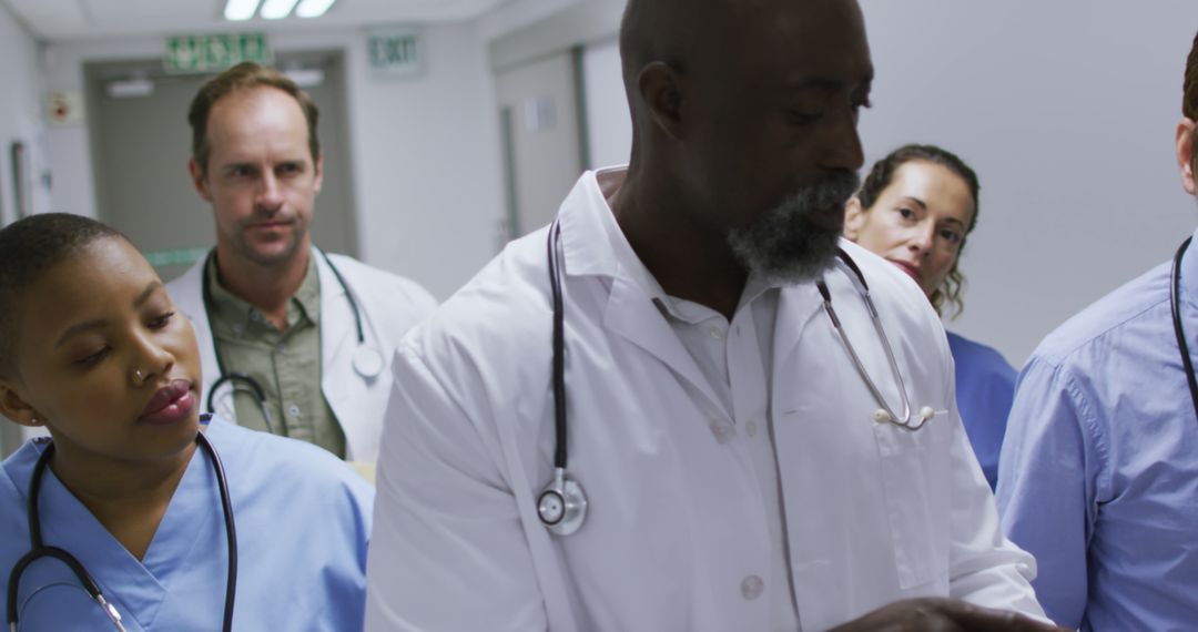 Medical Team of Doctors Walking Down Hospital Hallway - Free Images, Stock Photos and Pictures on Pikwizard.com