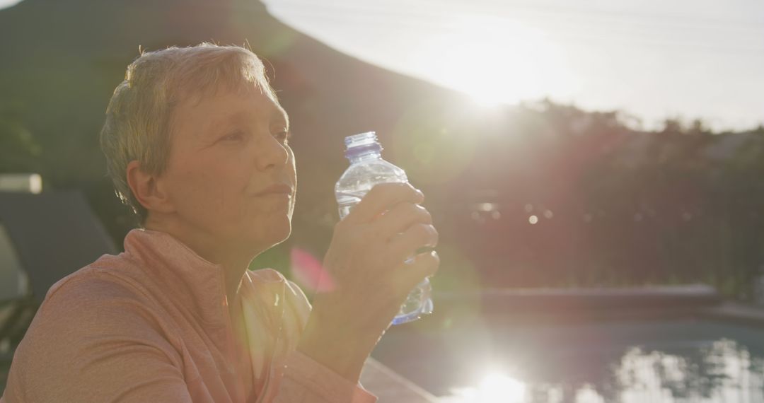 Senior Woman Drinking Water Outdoors During Sunrise - Free Images, Stock Photos and Pictures on Pikwizard.com