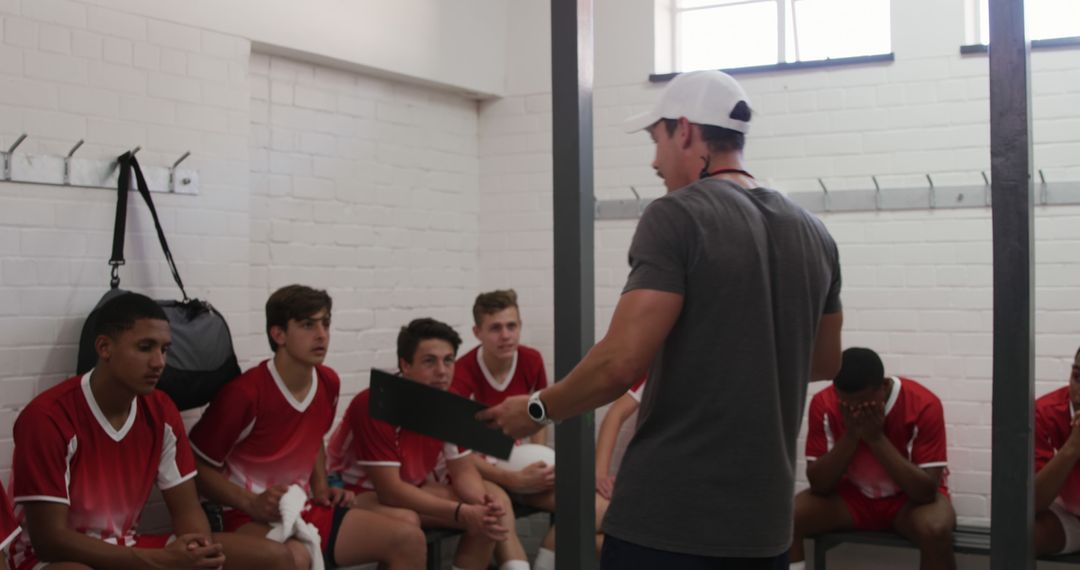 Coach giving pep talk to soccer team in locker room - Free Images, Stock Photos and Pictures on Pikwizard.com