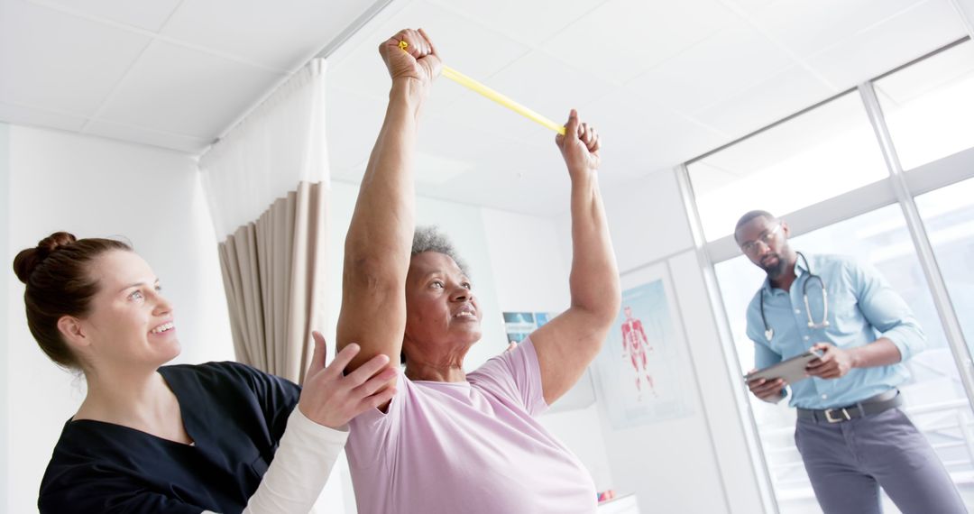 Senior Woman Exercising With Assistance in Physical Therapy Session - Free Images, Stock Photos and Pictures on Pikwizard.com