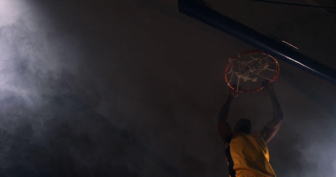 Basketball Player Dunking Under Dramatic Lighting on Indoor Court - Free Images, Stock Photos and Pictures on Pikwizard.com