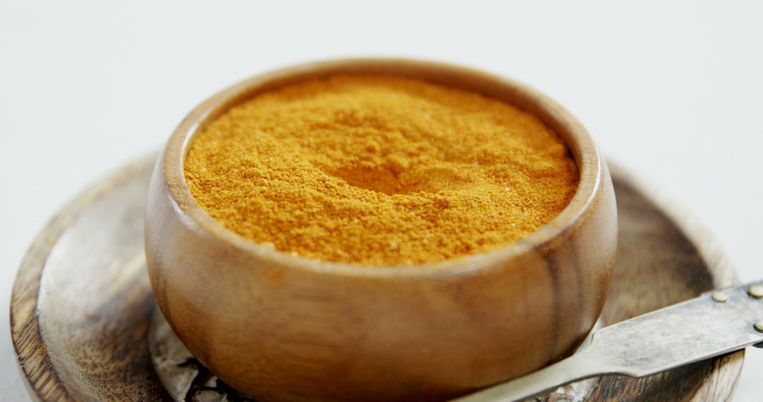 Wooden Bowl Filled with Turmeric Powder on Wooden Surface - Free Images, Stock Photos and Pictures on Pikwizard.com