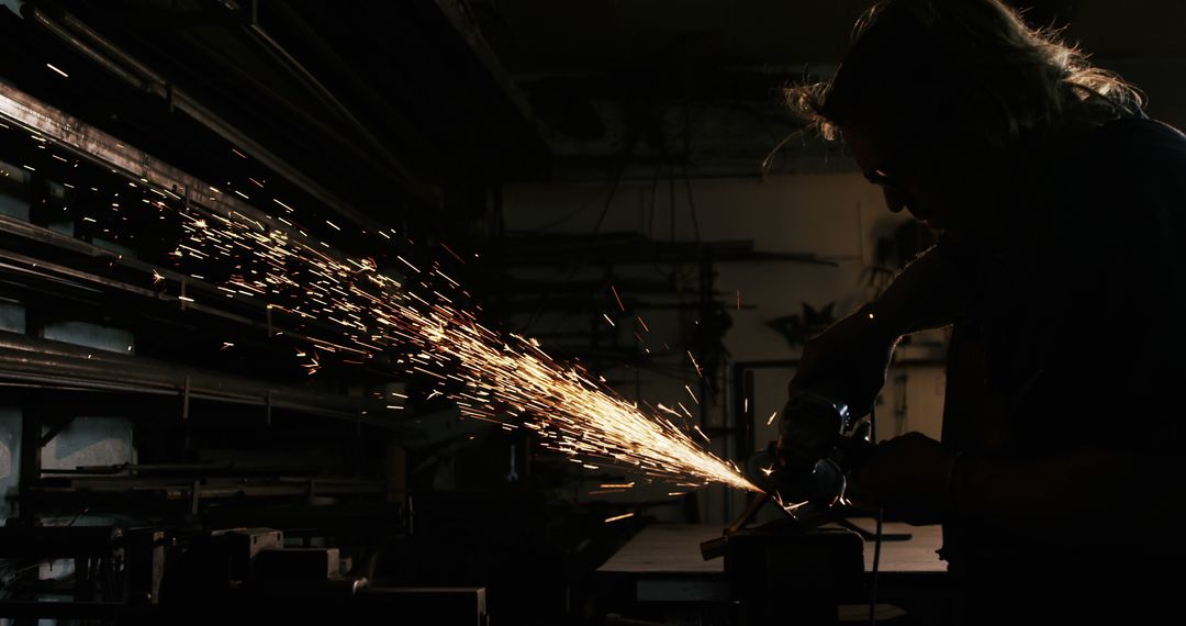 Worker Using Angle Grinder in Dark Workshop with Sparks Flying - Free Images, Stock Photos and Pictures on Pikwizard.com