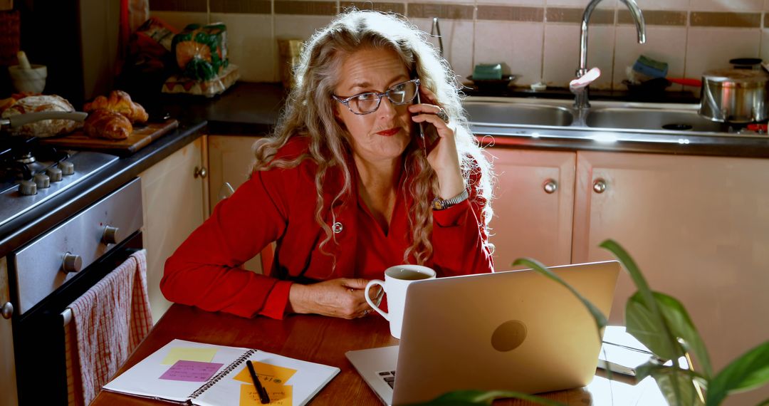 Mature Woman Working from Home at Kitchen Table - Free Images, Stock Photos and Pictures on Pikwizard.com