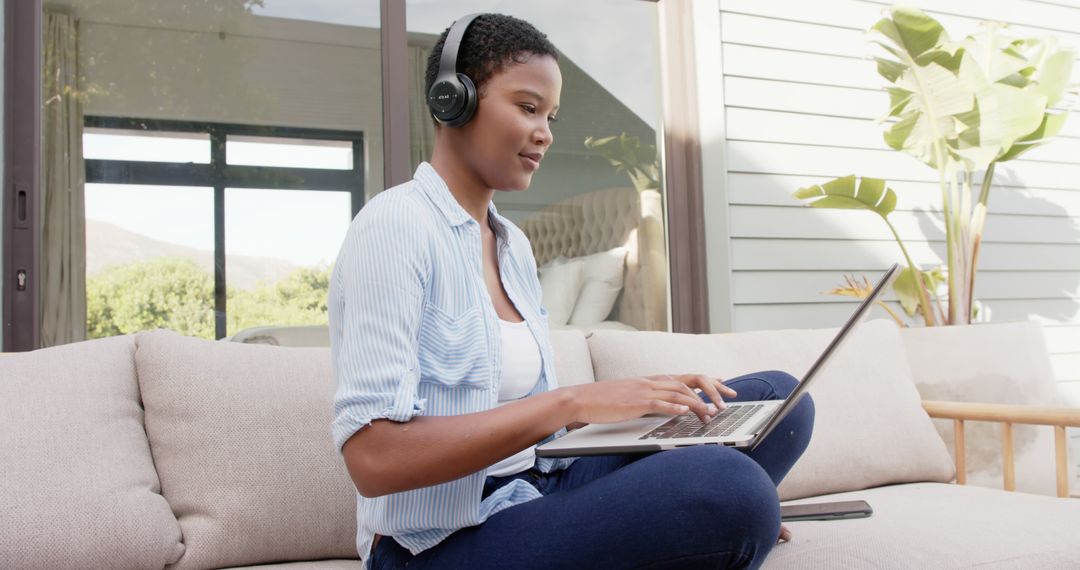 Woman Relaxing on Patio Using Laptop and Wearing Headphones - Free Images, Stock Photos and Pictures on Pikwizard.com