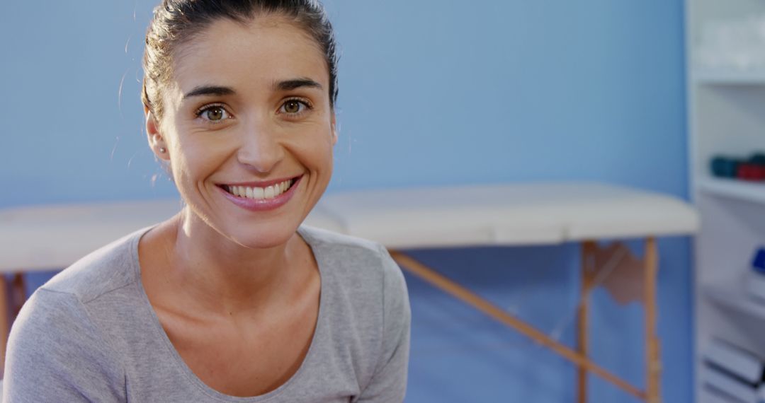 Smiling Woman in Health Clinic with Blue Background - Free Images, Stock Photos and Pictures on Pikwizard.com